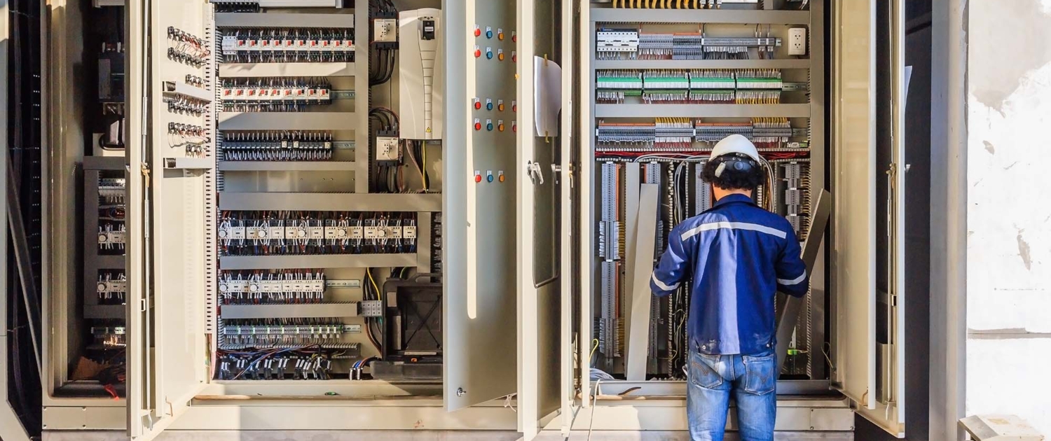 Instrument technician on the job check wiring on PLC cabinet